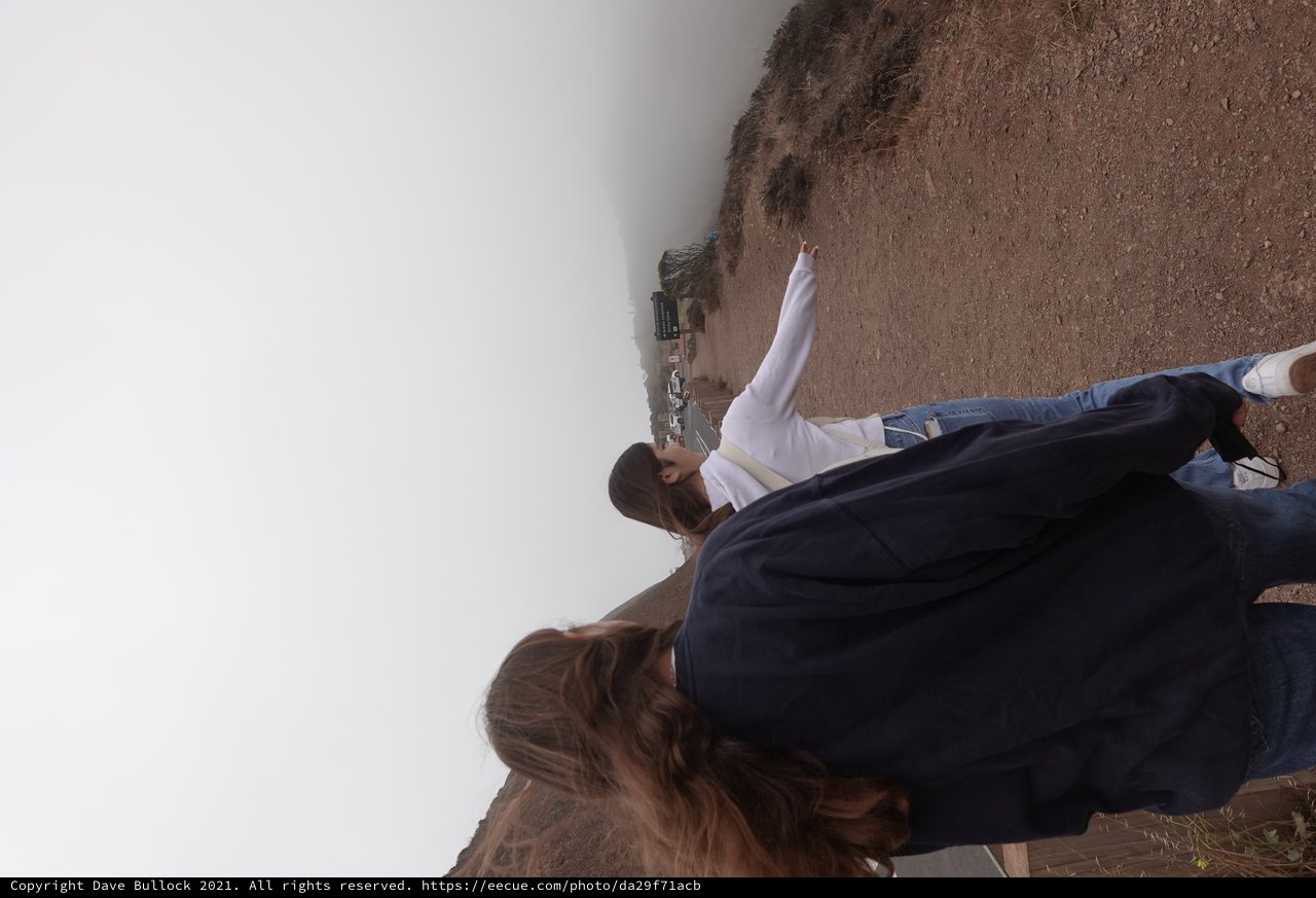 Two Women Walking on Foggy Coastal Trail