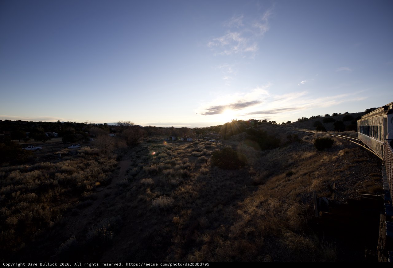 Desert Sunset Over Scrubland and Distant Community
