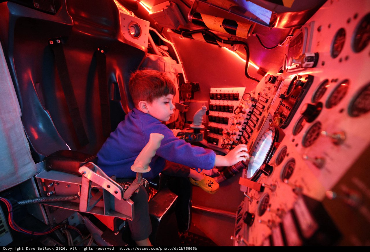 Young Astronaut Explores Space Capsule Interior at Museum