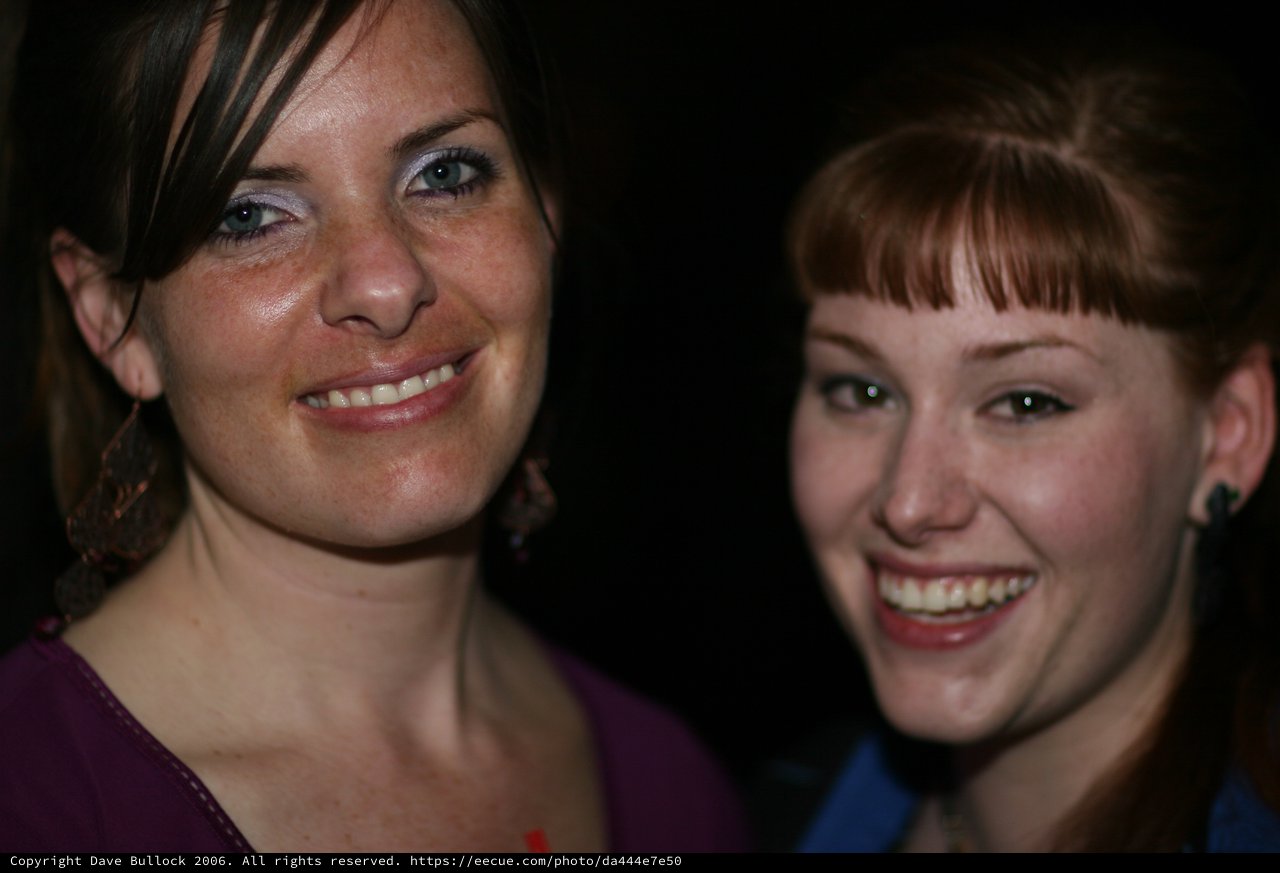 Two Young Women Smiling at a Nighttime Event