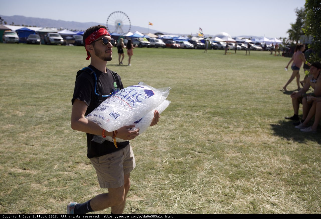 A man carrying a large bag of ice to beat the heat