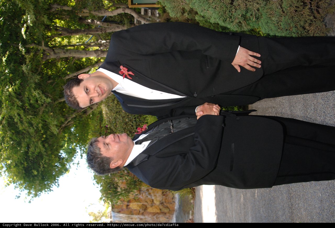 Two Men in Tuxedos Share a Handshake at Wedding