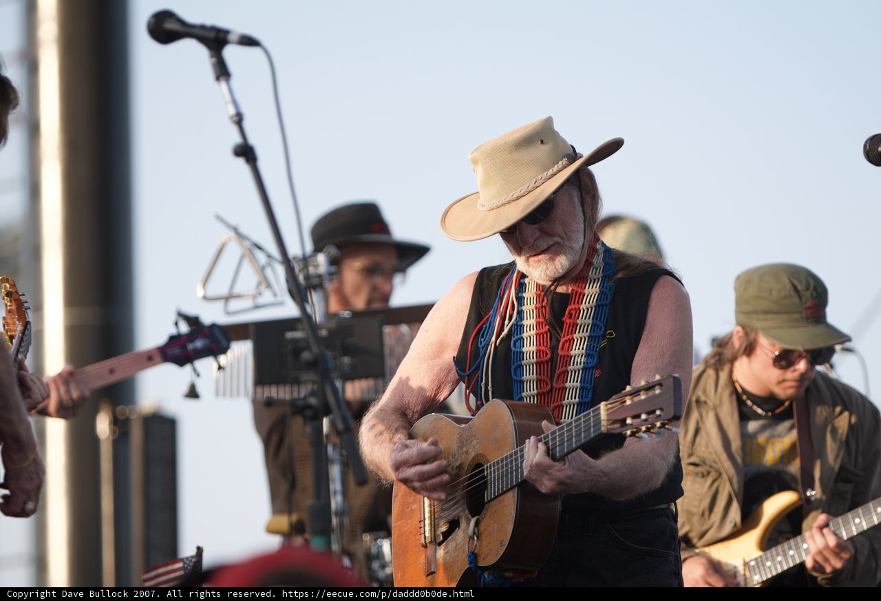 Willie Nelson strums his guitar and sings to the skies