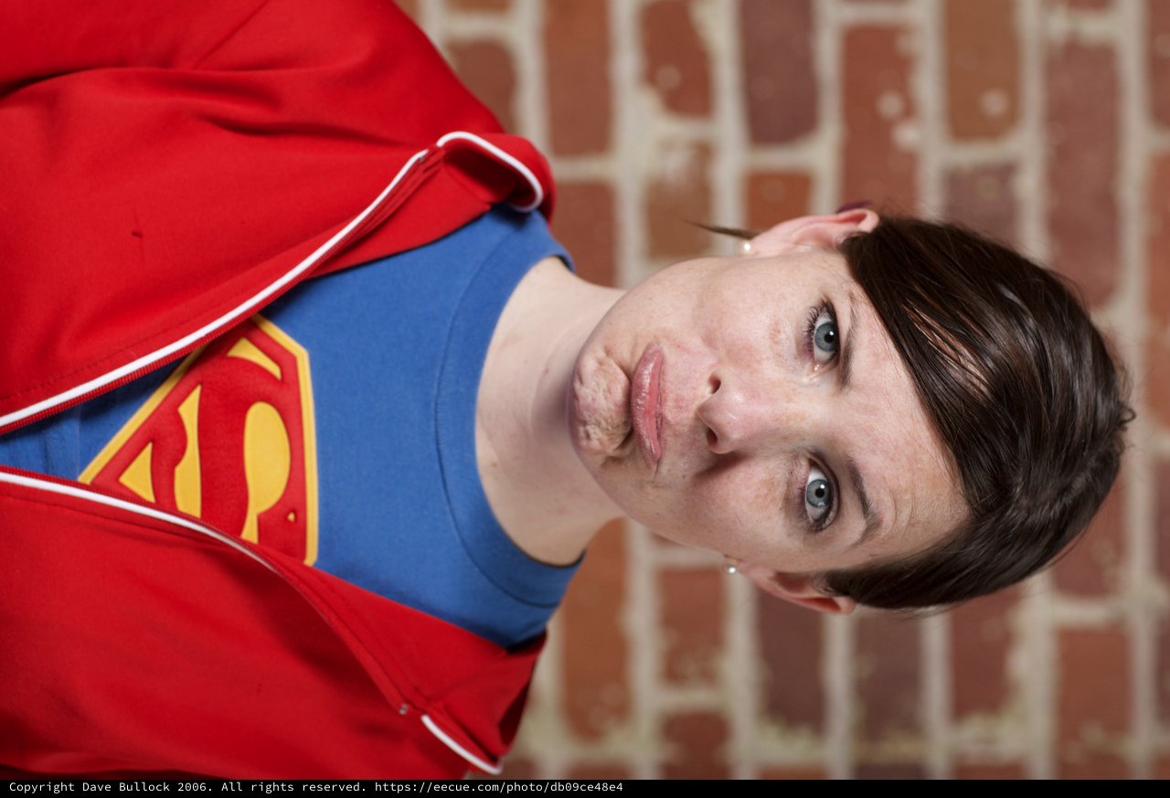 Supergirl Pouting Against Brick Wall Portrait