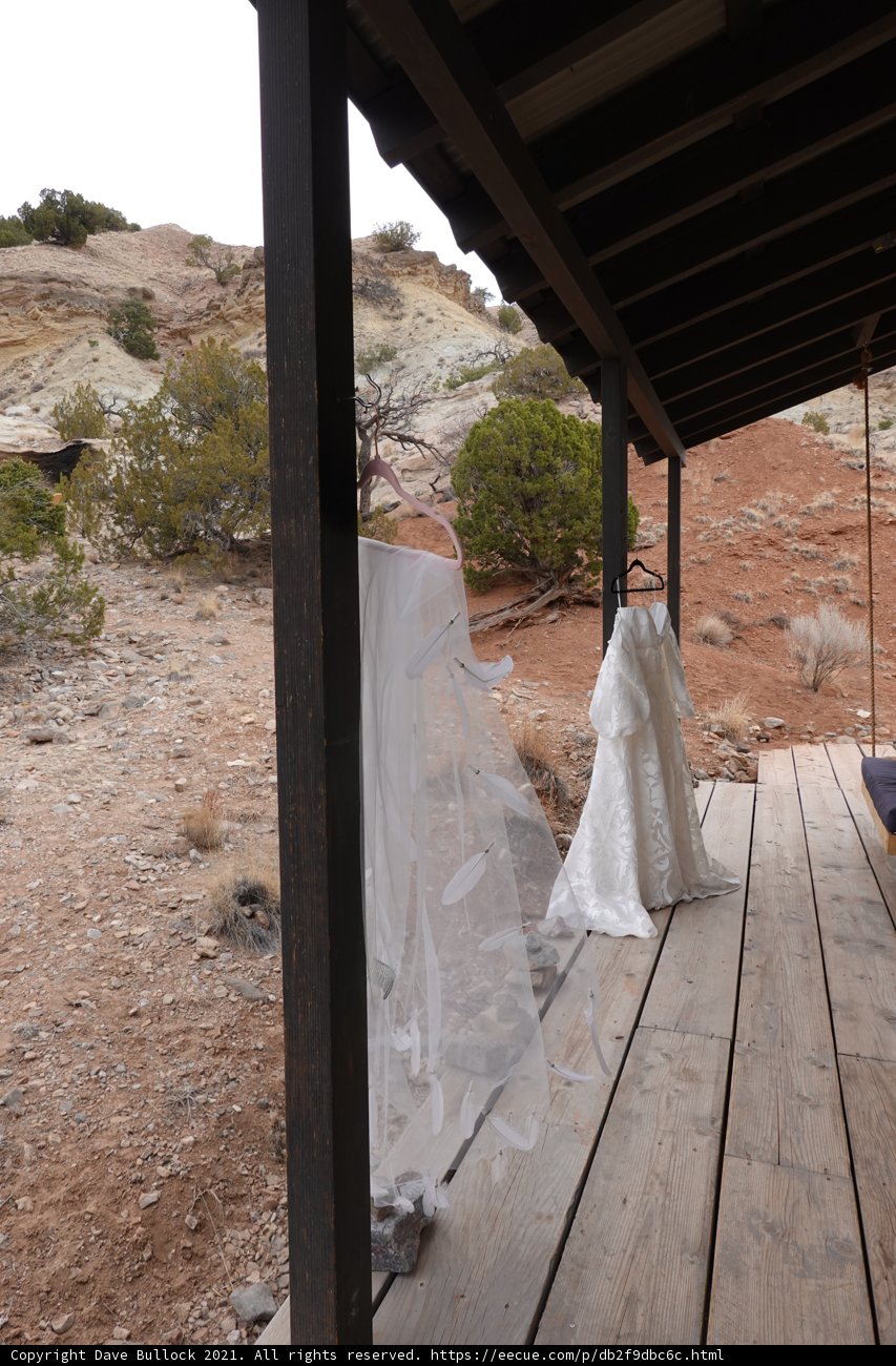 Elegant Wedding Dress Hanging on a Rustic Wooden Porch