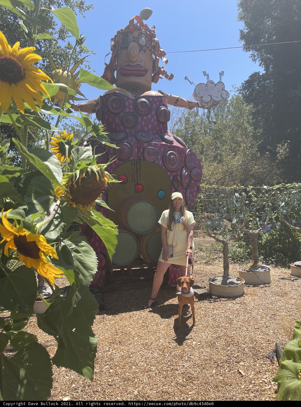 Woman and Dog Pose in Front of Giant Park Sculpture