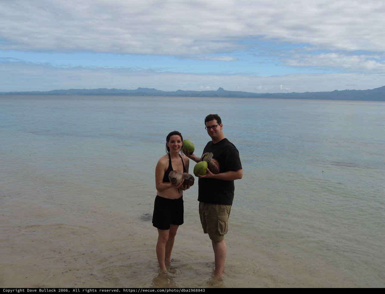 Couple Celebrating with Fresh Coconuts on Fijian Shore