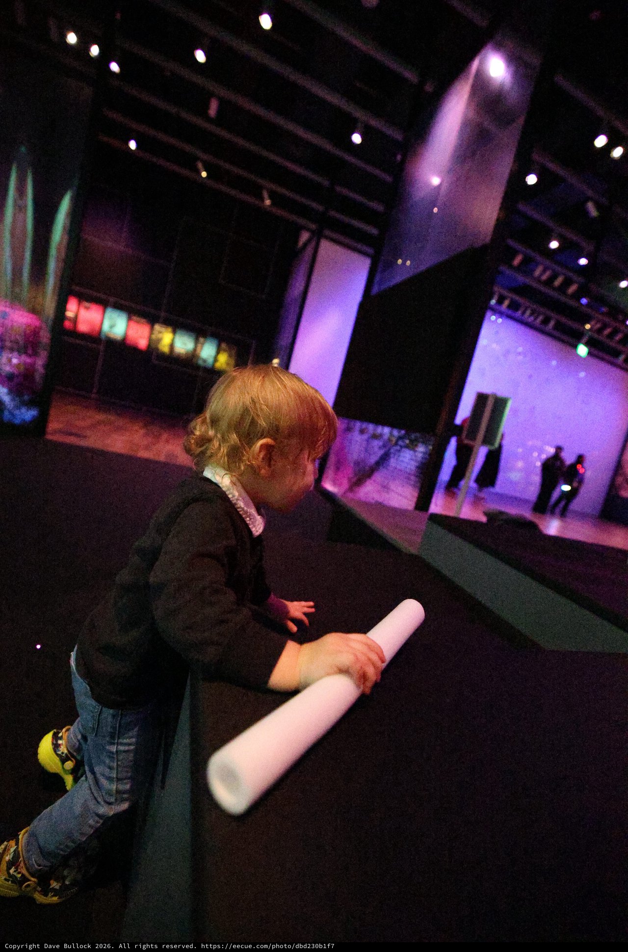 Child Exploring Interactive Light Installation at Museum