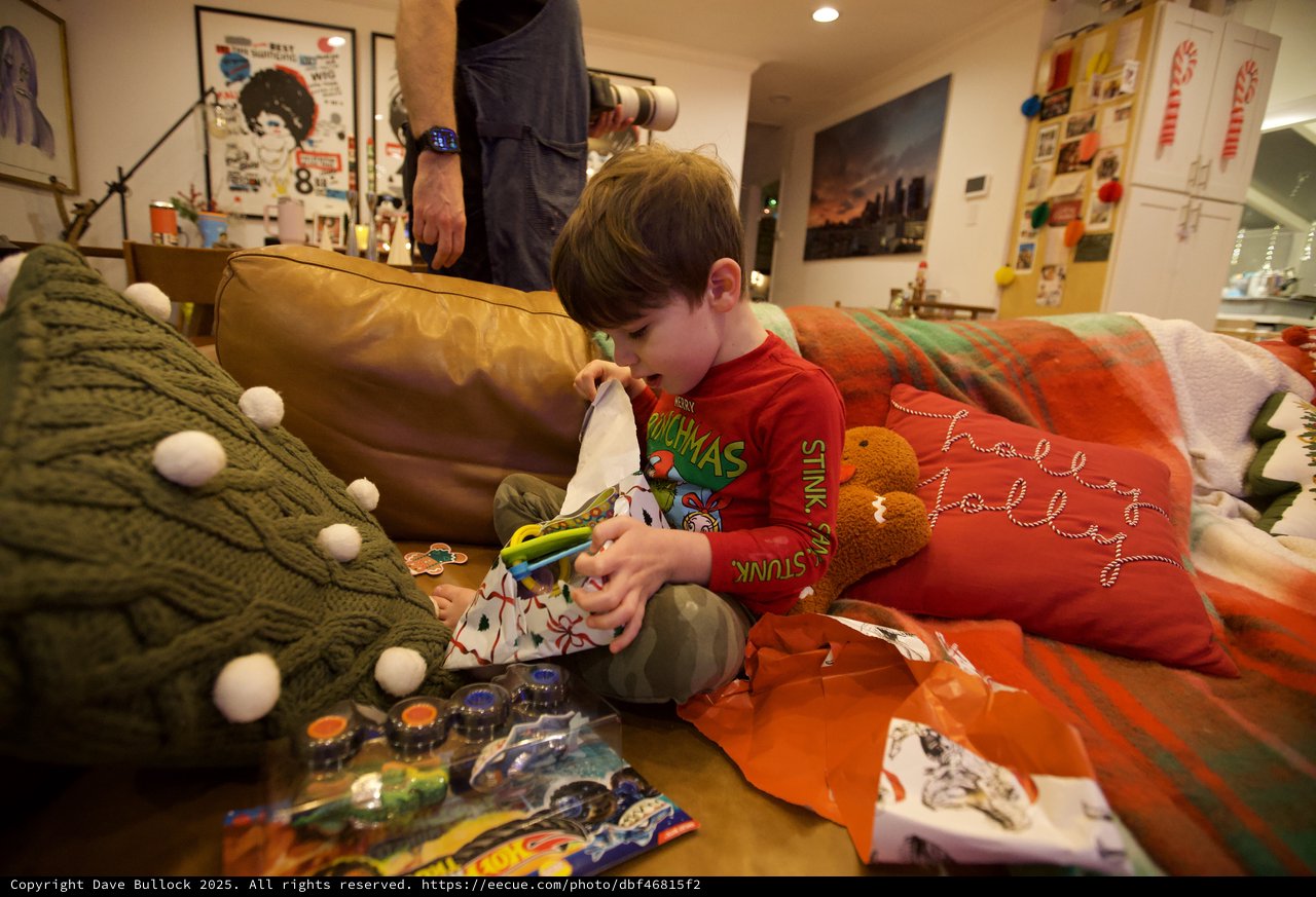 Child Opening Christmas Stocking on Cozy Living Room Sofa