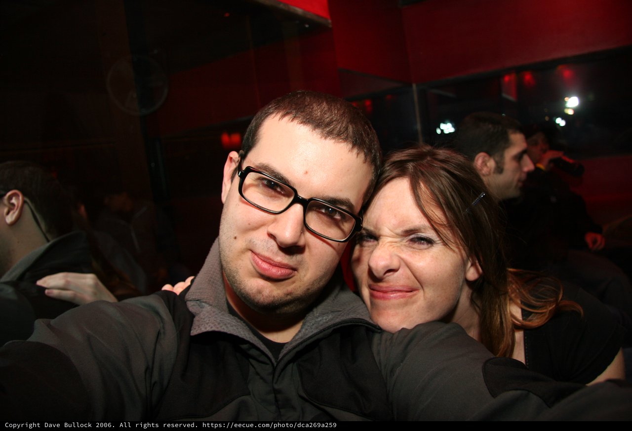 Friends Pose Together at Dimly Lit Night Venue