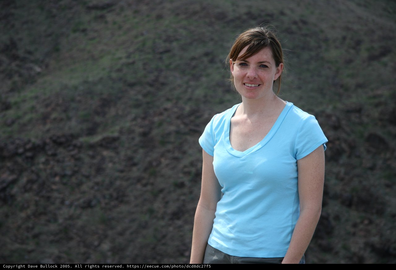 Young Woman Smiling Outdoors on Rocky Hillside