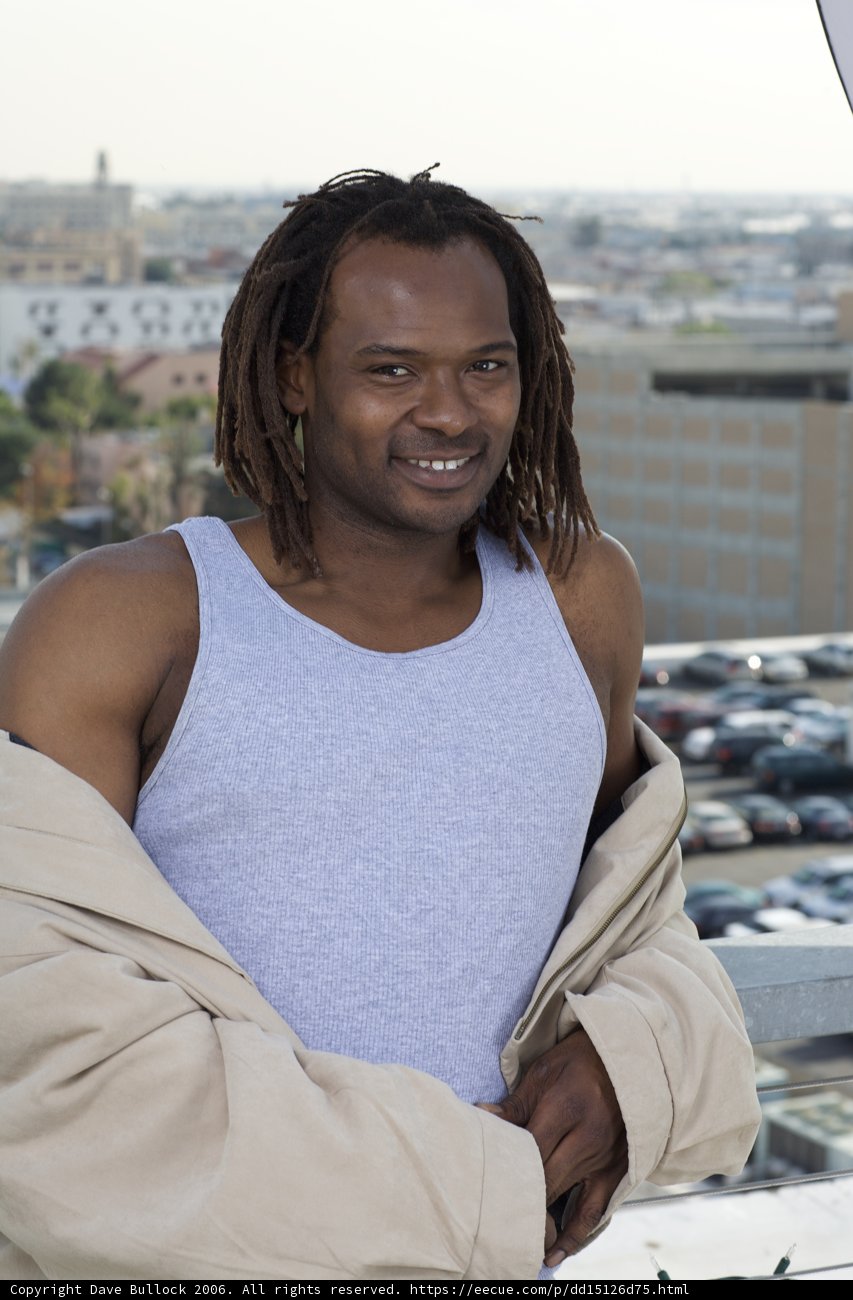 Happy Dreadlocked Man Poses with Car