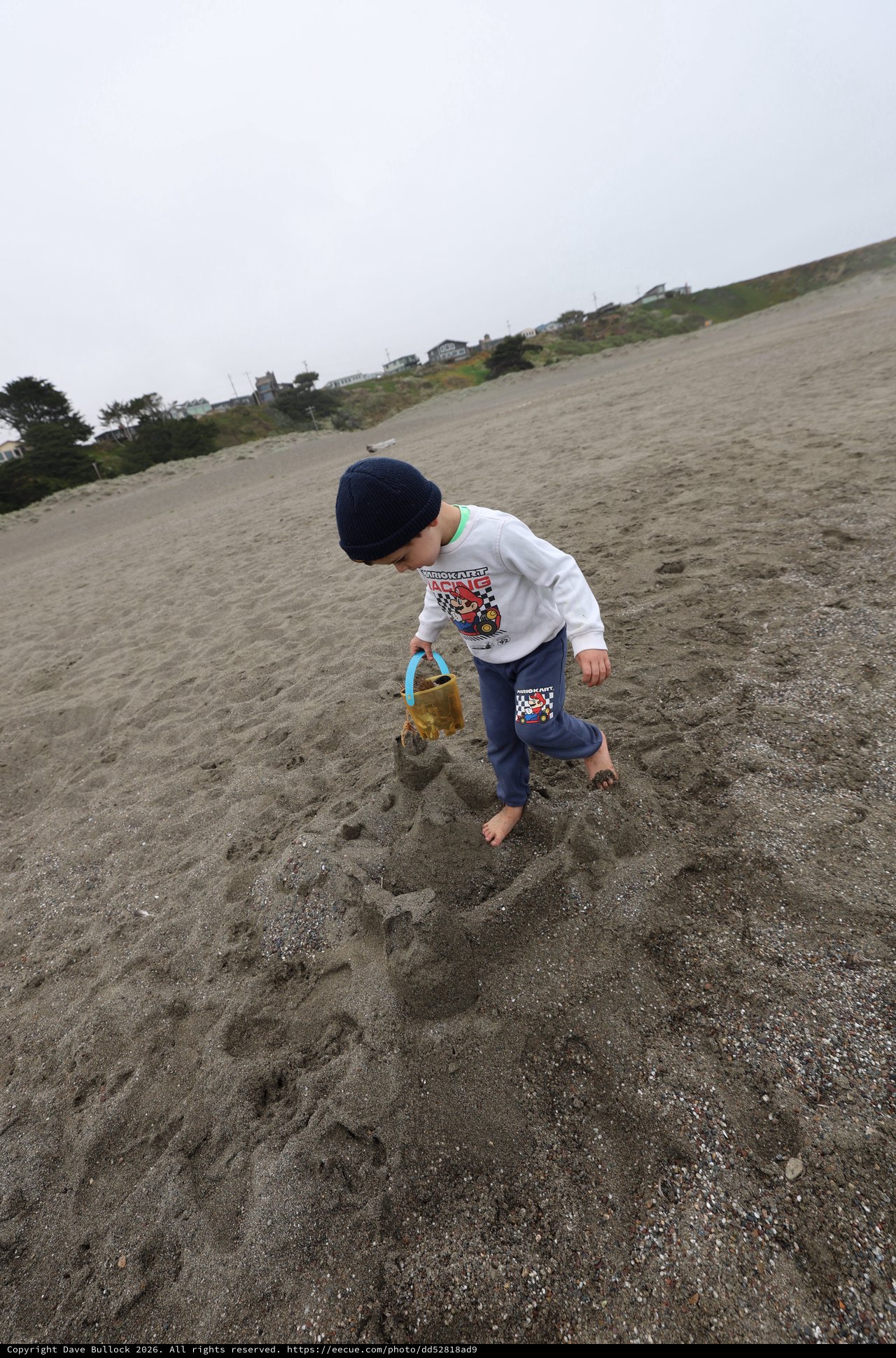 Young Boy Building Sandcastles on a Foggy Beach