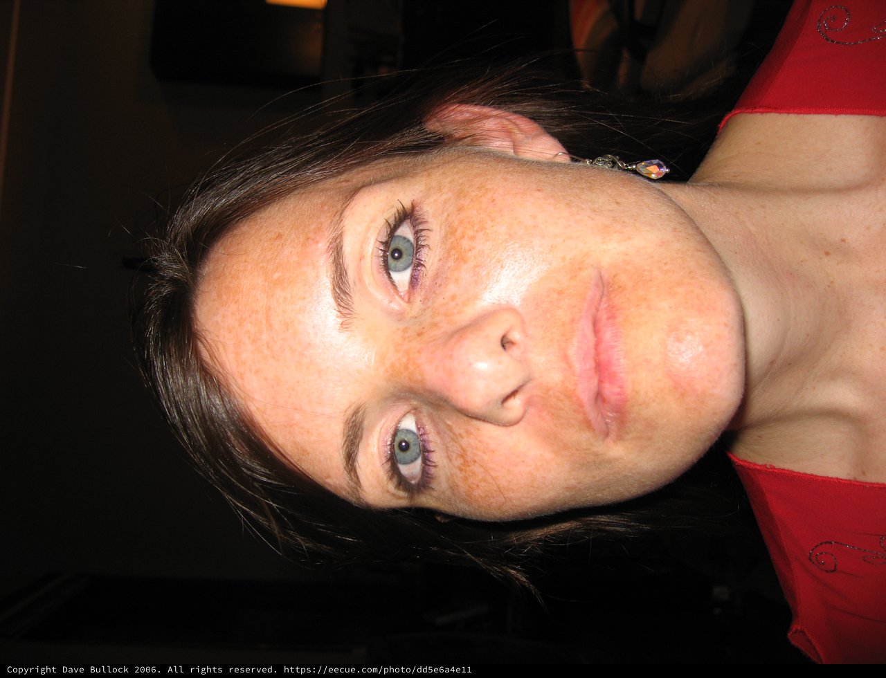 Freckled Woman in Red at Indoor Night Setting