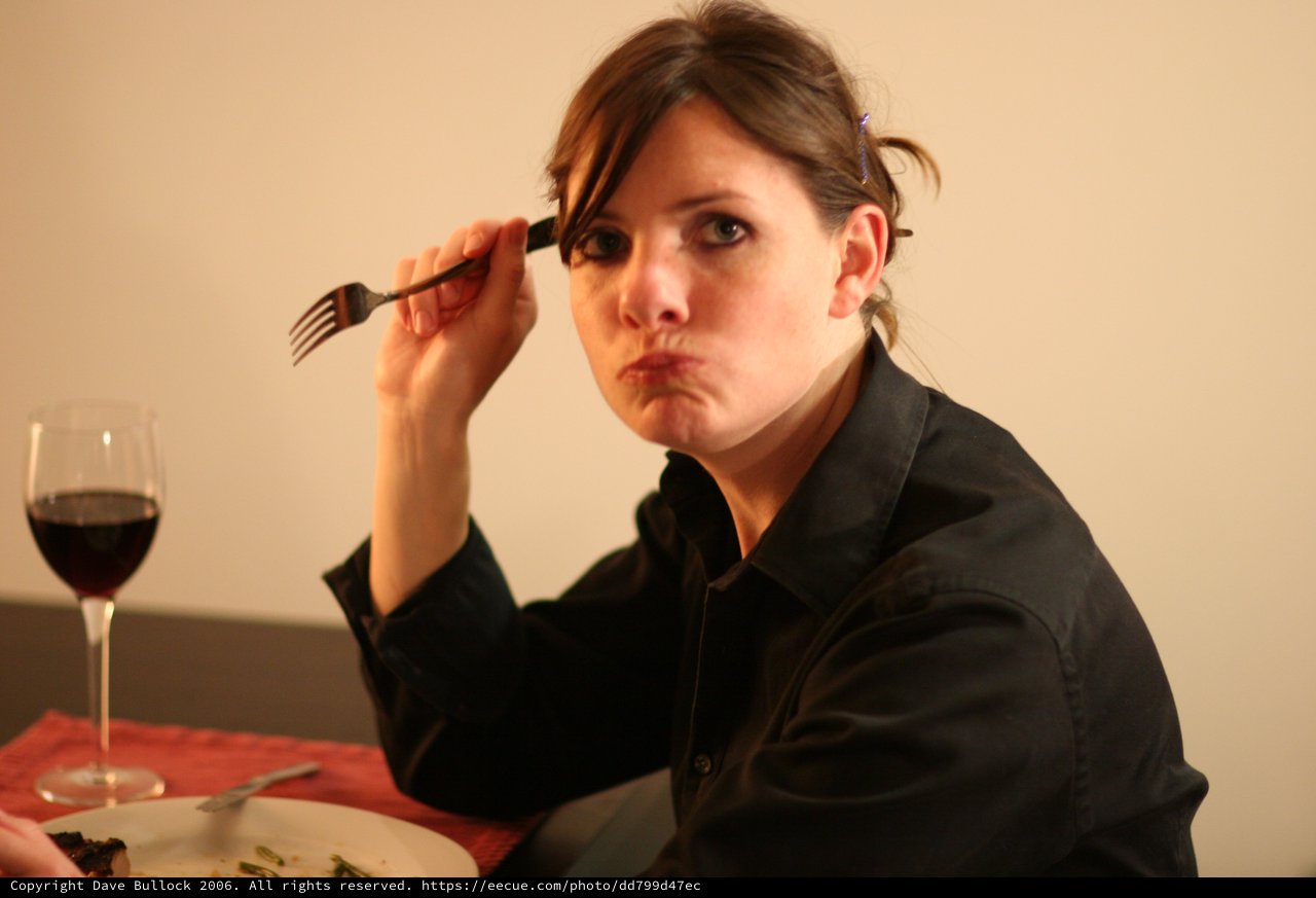 Unamused Woman at Dinner with Red Wine