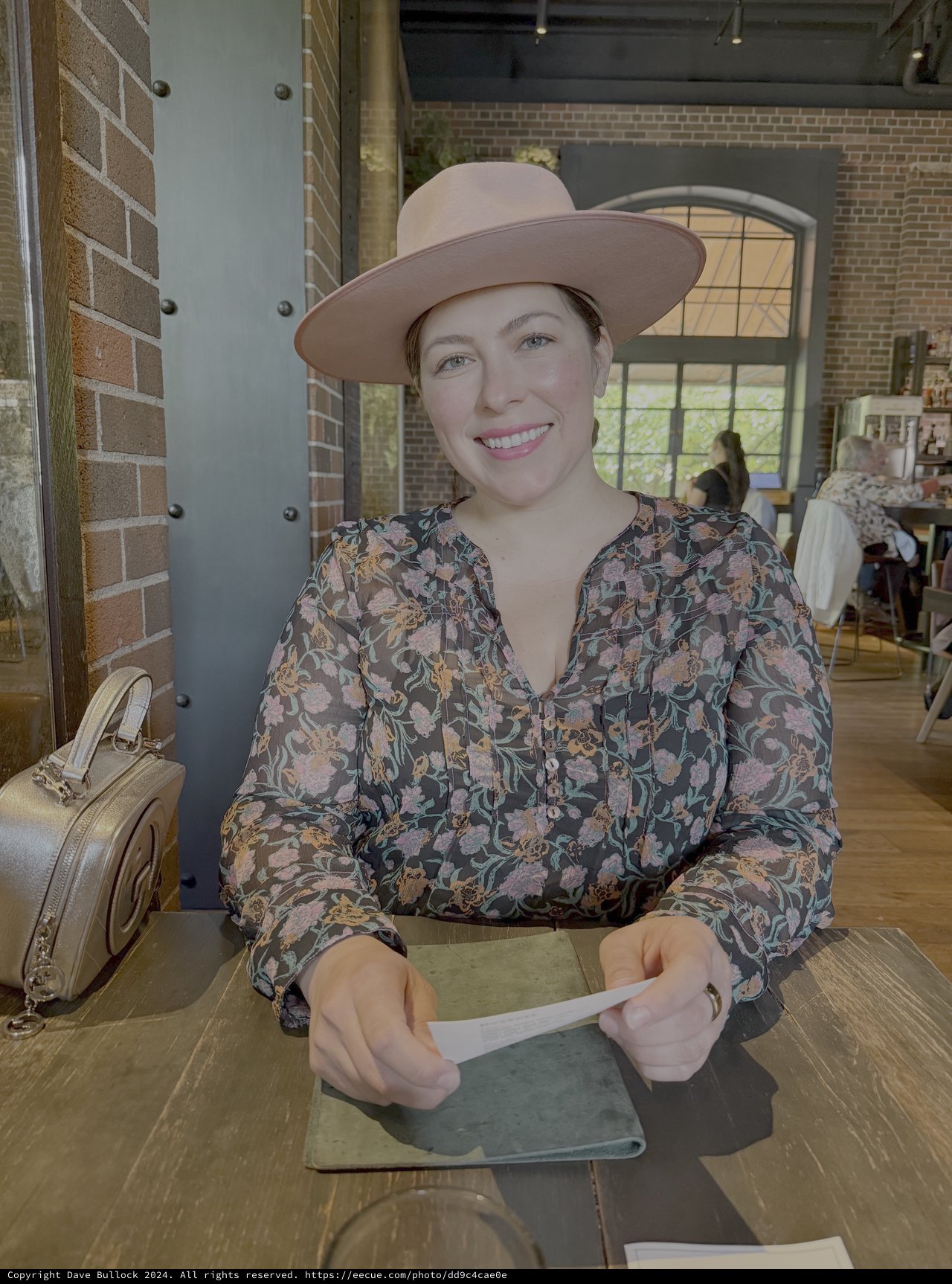 Woman in Wide-Brimmed Hat at Trendy Cafe