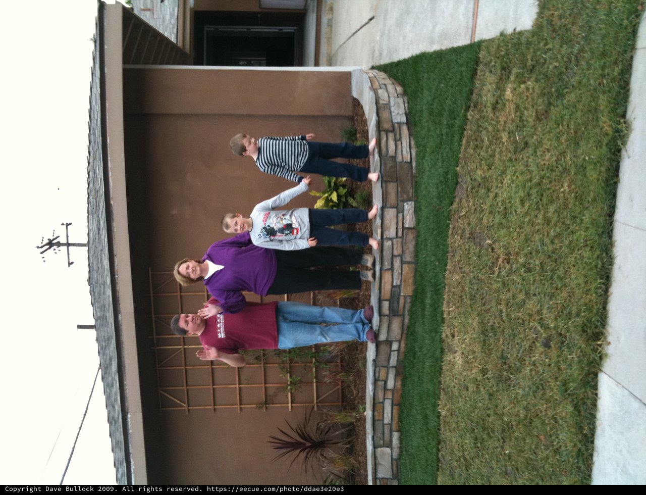 Family Waving Together in Front of Home