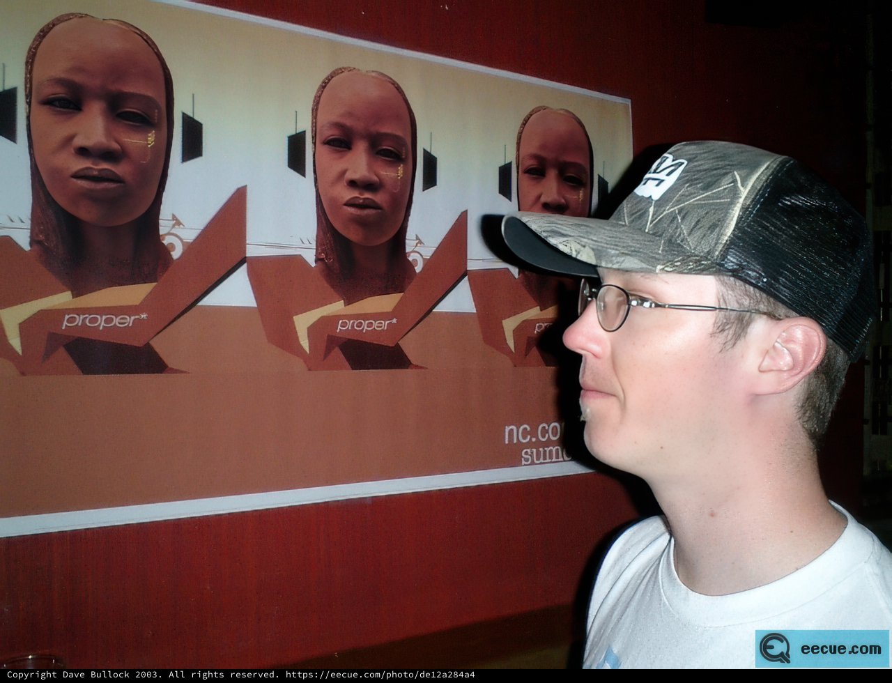 Andrew T checking out a poster in his cool hat and glasses