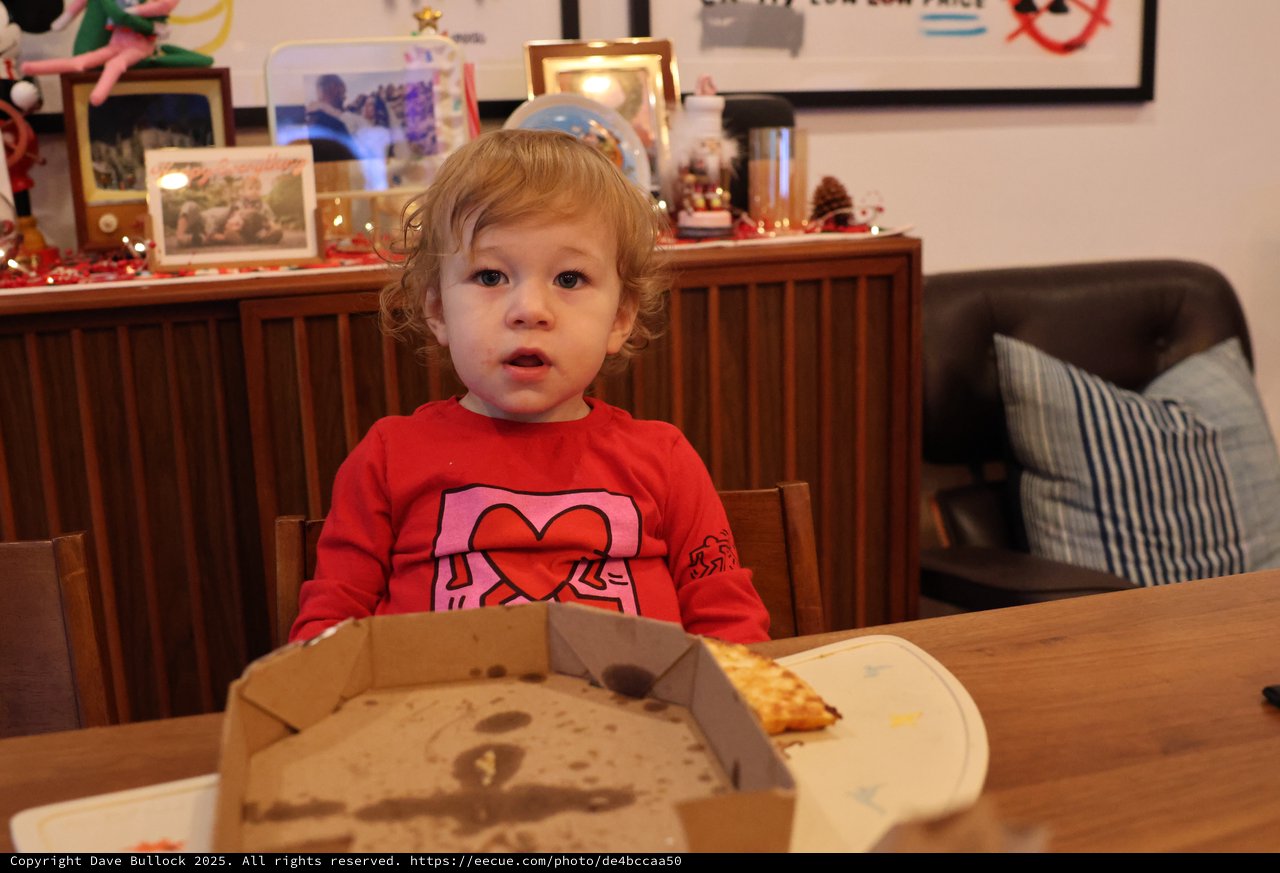 Toddler Enjoying Pizza at Christmas Dinner Table
