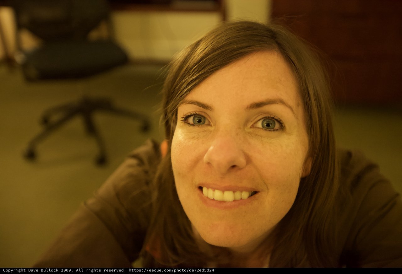 Smiling Woman with Blue Eyes in Office Setting