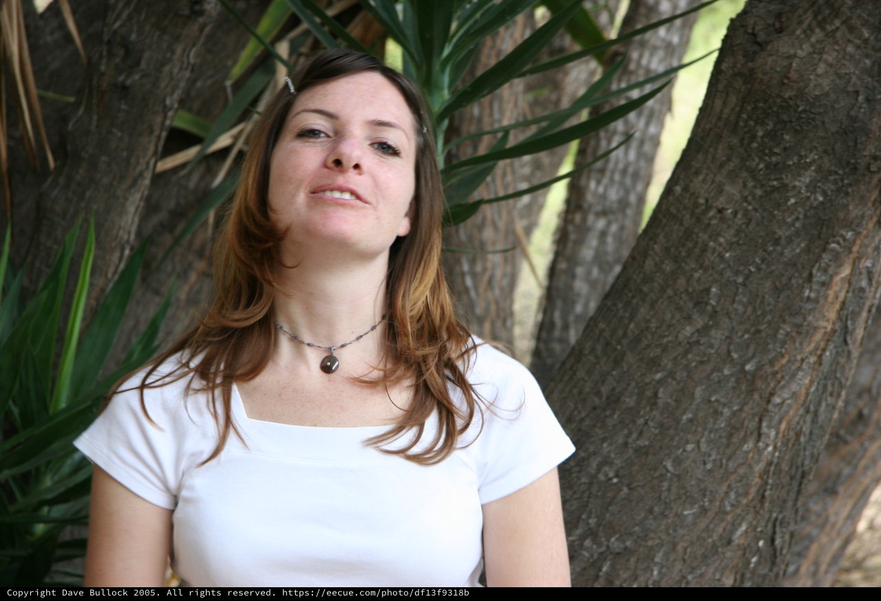Woman Smiling Serenely Beneath Tropical Trees
