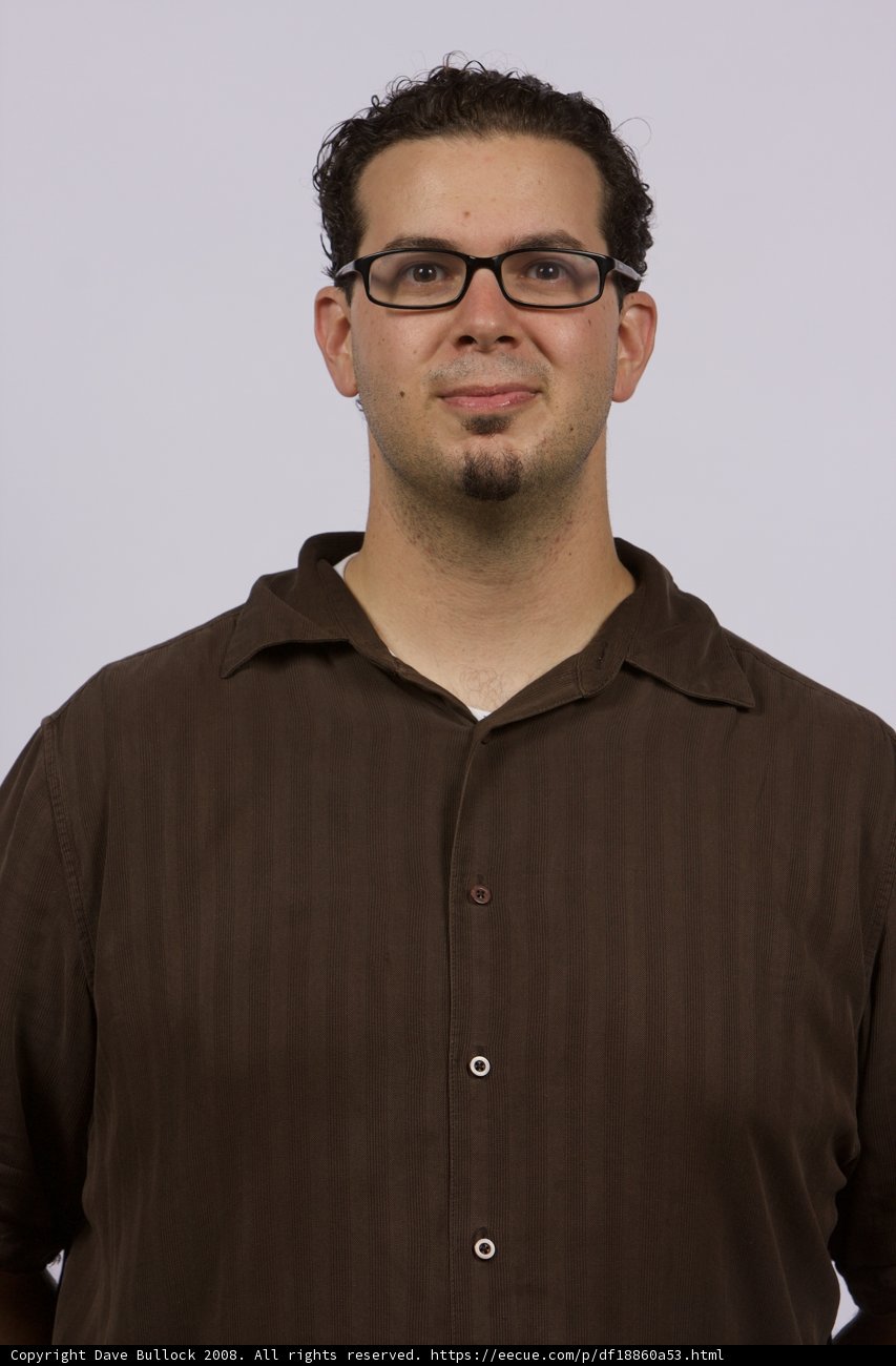 Smiling Man in Glasses and Brown Shirt