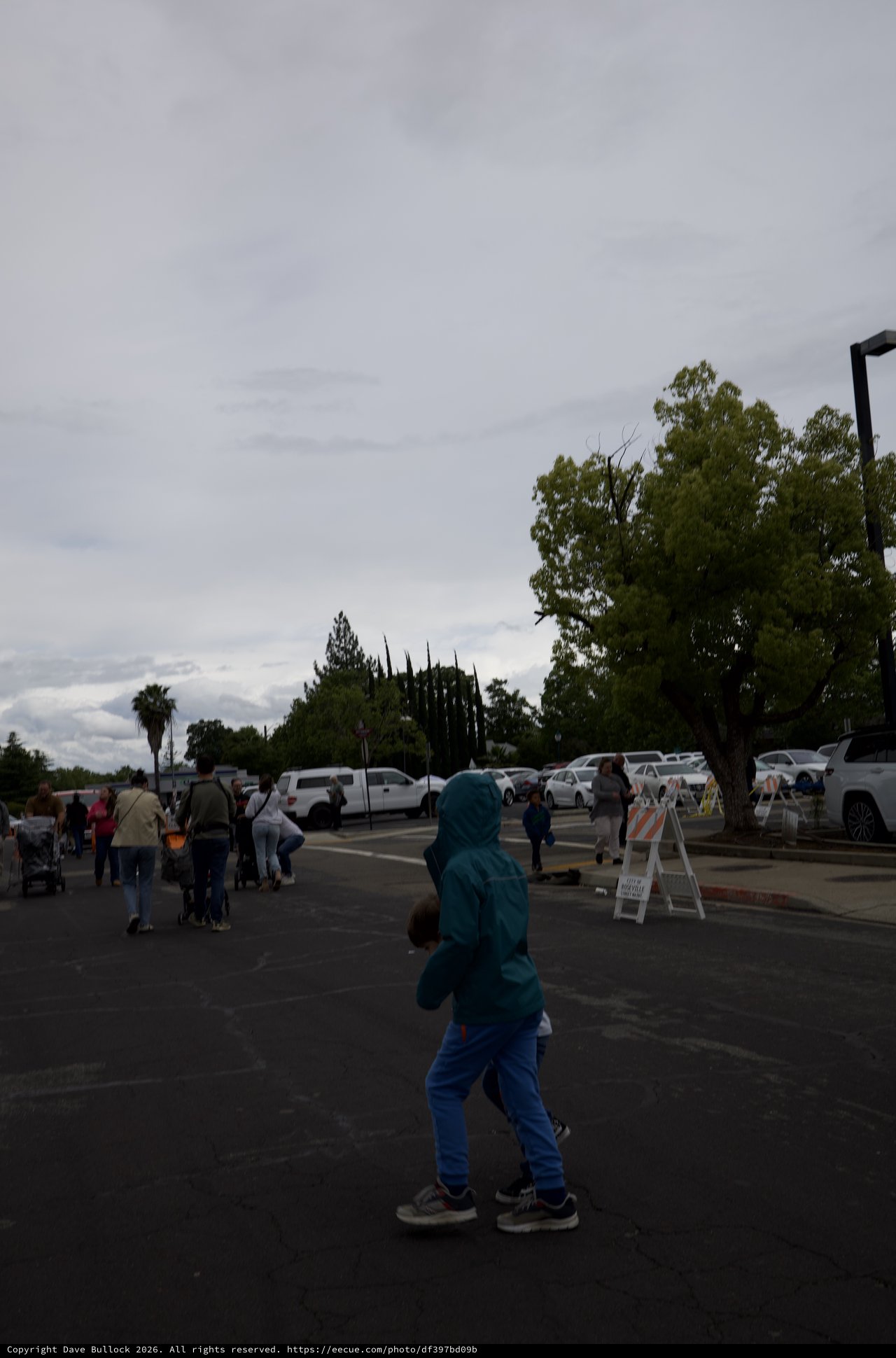 Child in Turquoise Hoodie at Community Gathering