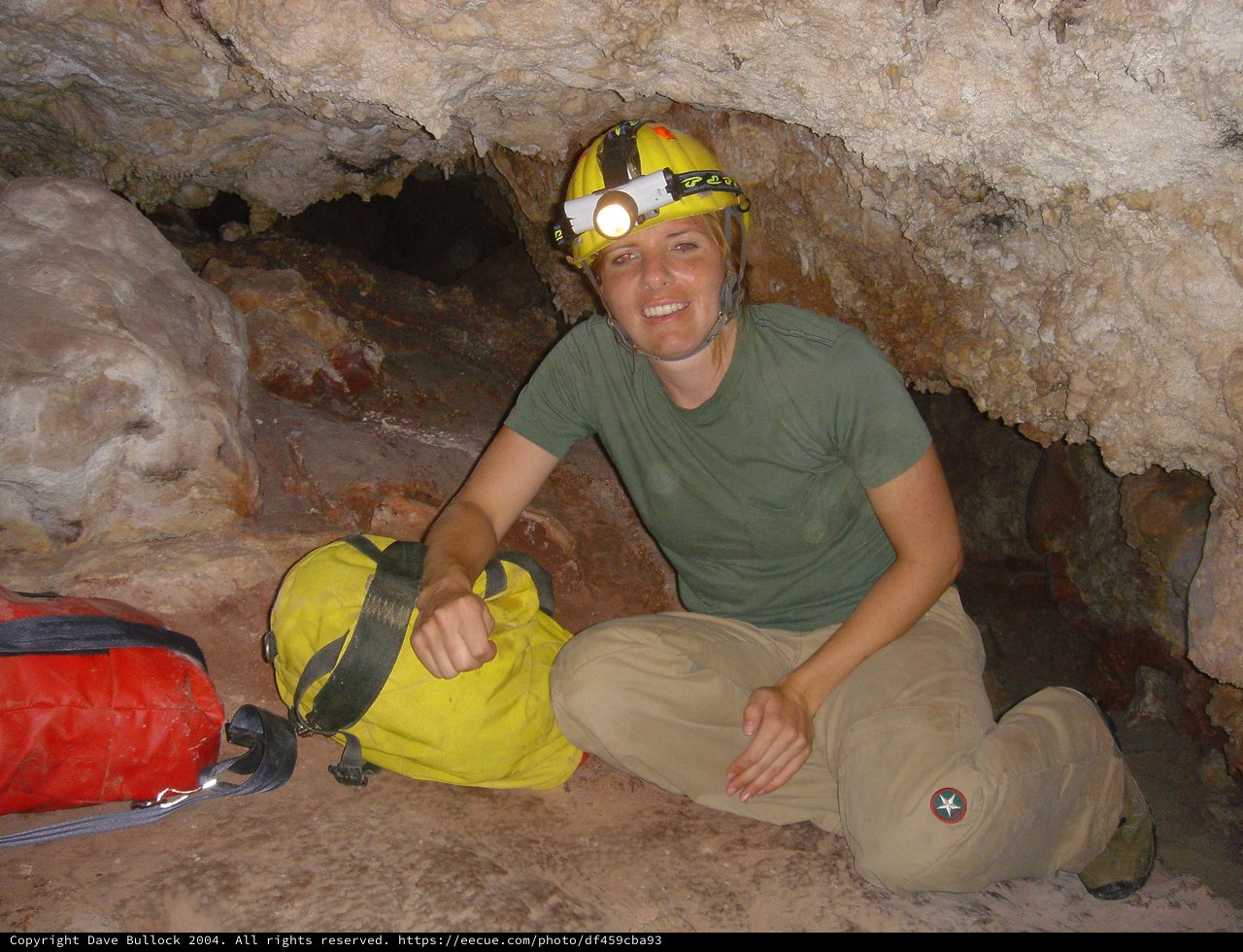 Underground Explorer Poses in Limestone Cave Passage