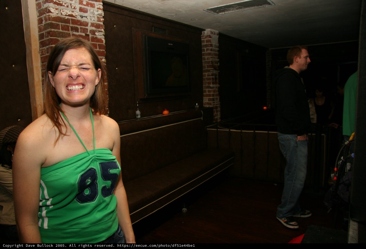 Woman in Green Jersey Laughing at Bar Party