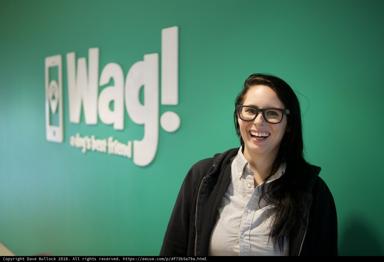 Happy Woman in Glasses with Wag Logo