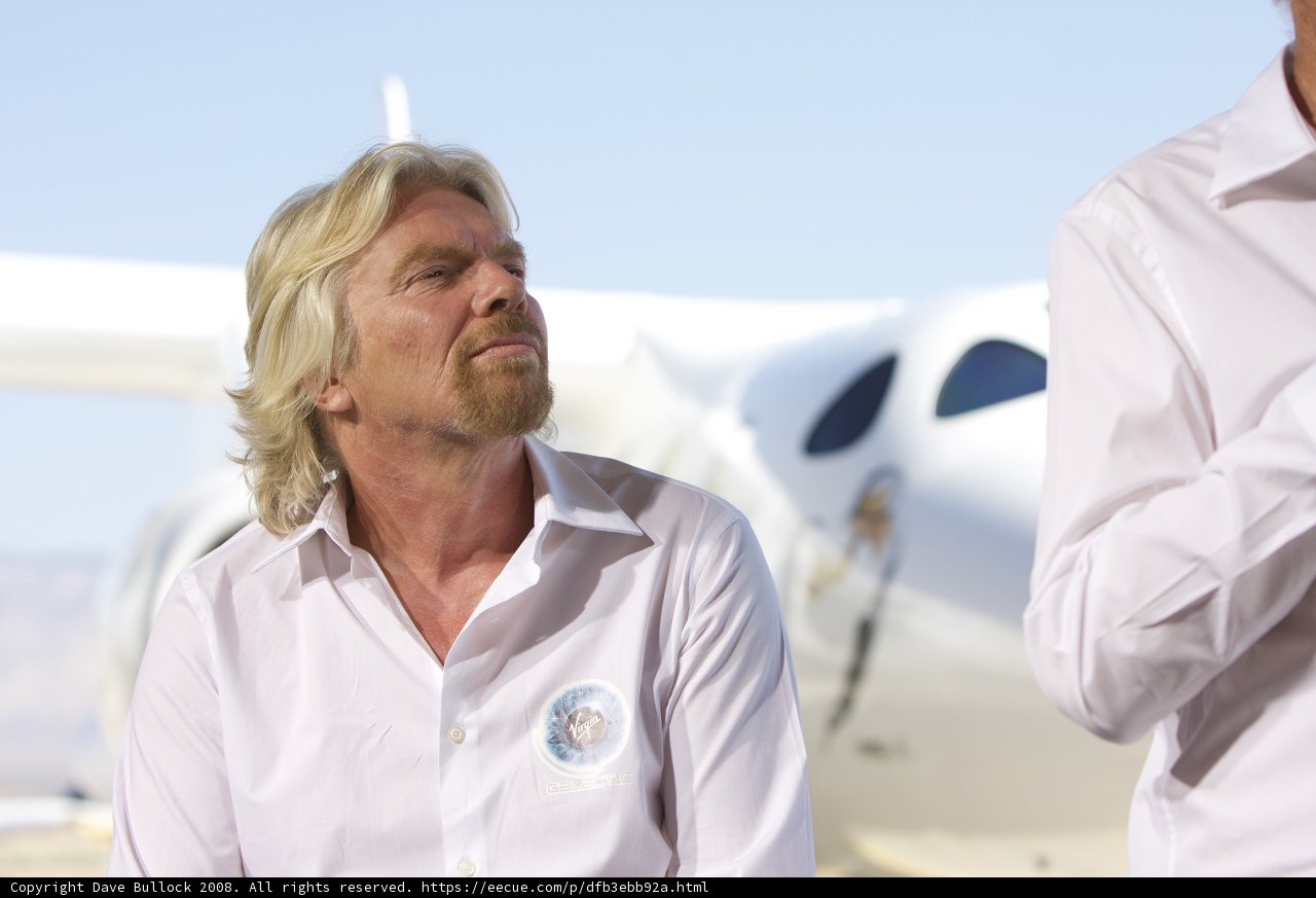 Two Men in White Shirts next to a Blue Sky Plane