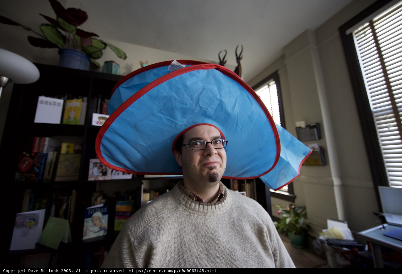 The Hat-Wearing Man at His Desk