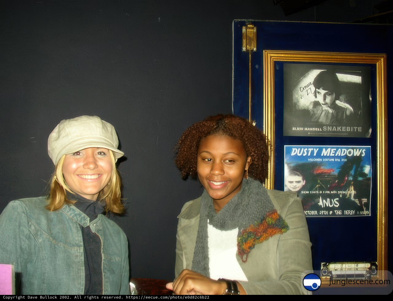 Women Posed Next to Artwork Poster