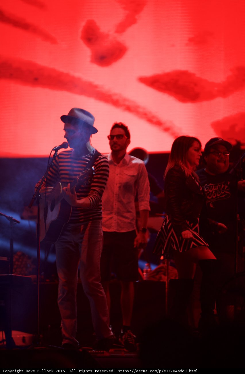 Belle and Sebastian Stuart Murdoch Acoustic Guitar Man Glasses Woman Chevron Man Cap Red Stage