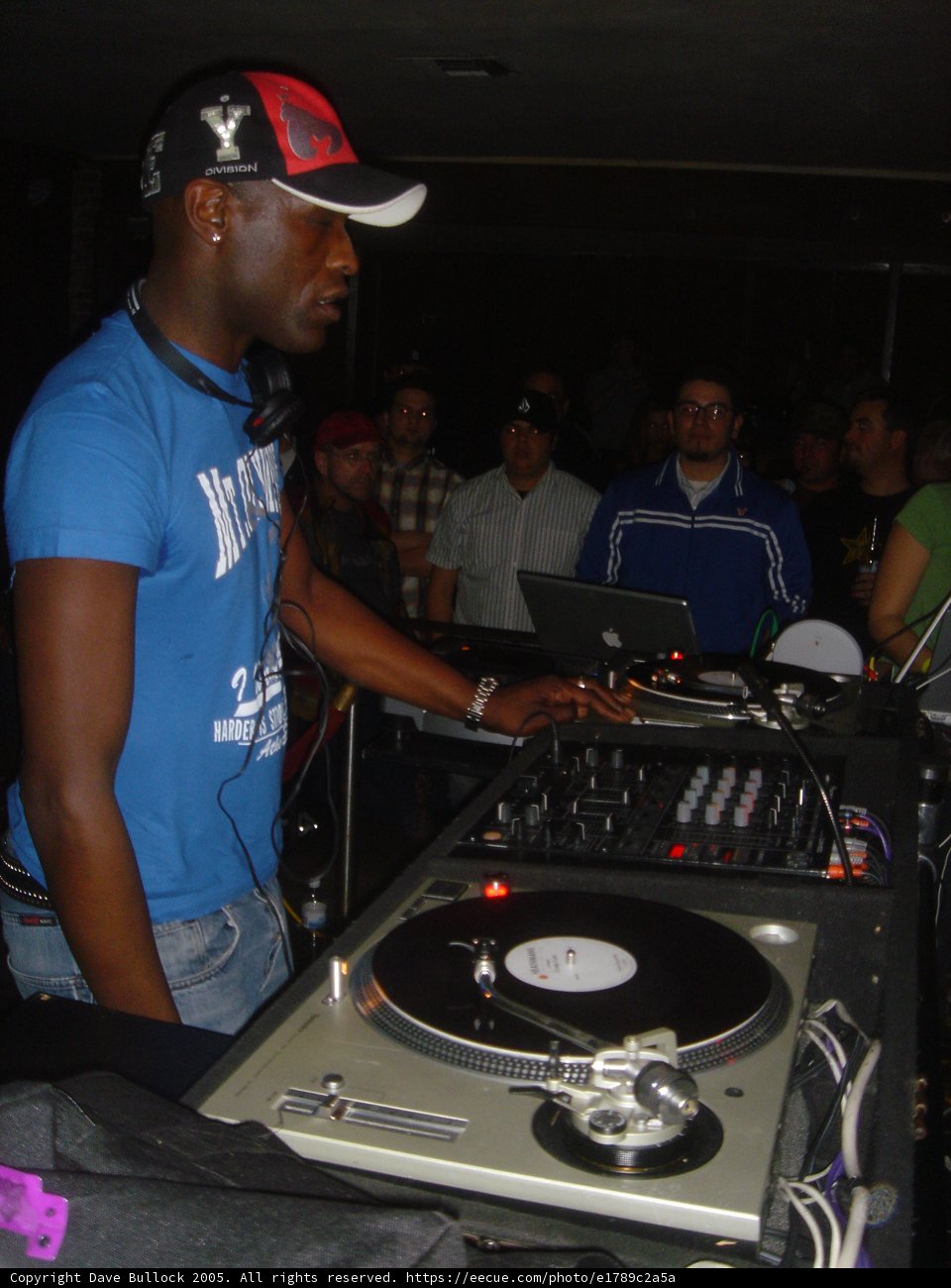 Blue-Shirted Man DJs at Nightclub