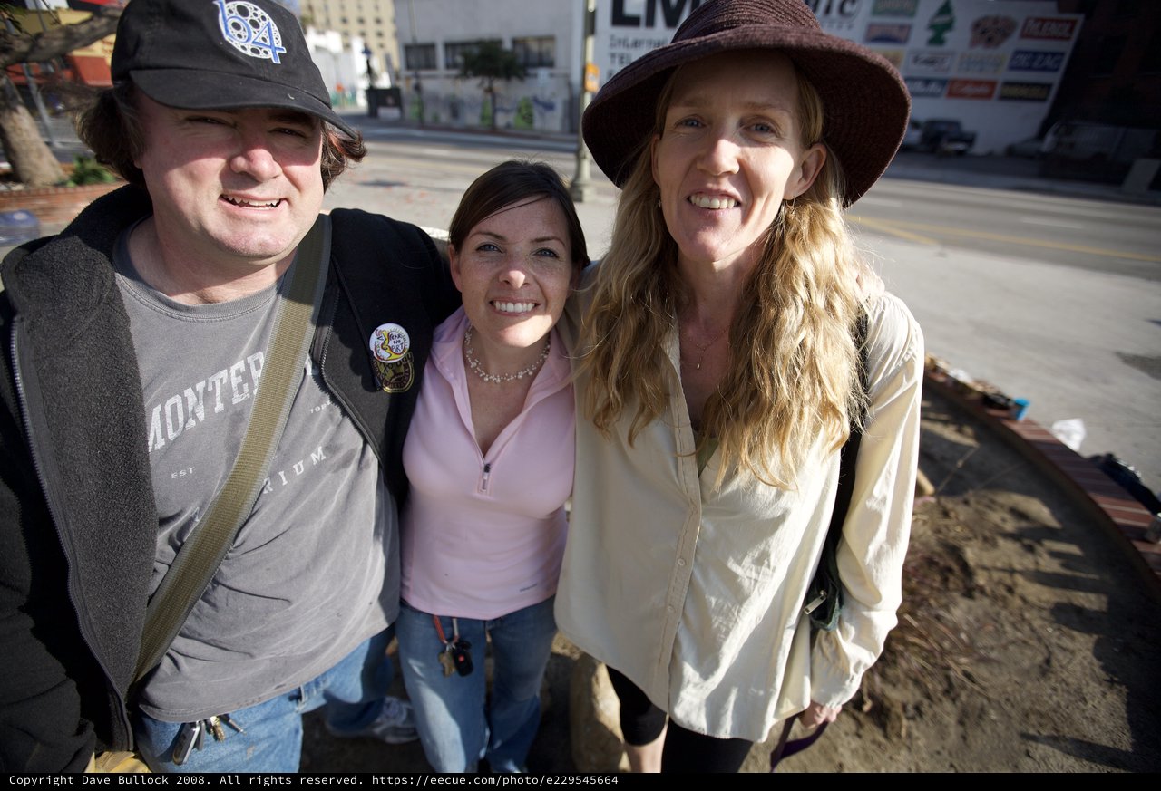 Three Friends Smiling Together on Urban Street