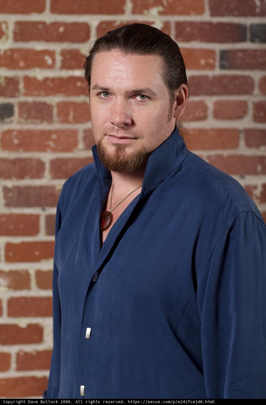 Smiling man with a blue shirt and a beard