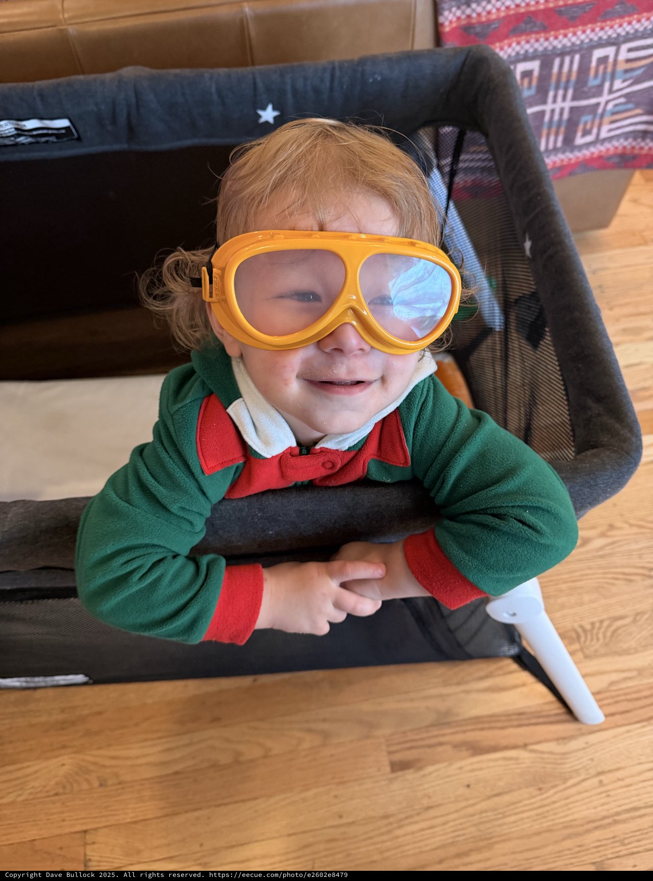 Joyful Toddler in Aviator Goggles and Green Sweater