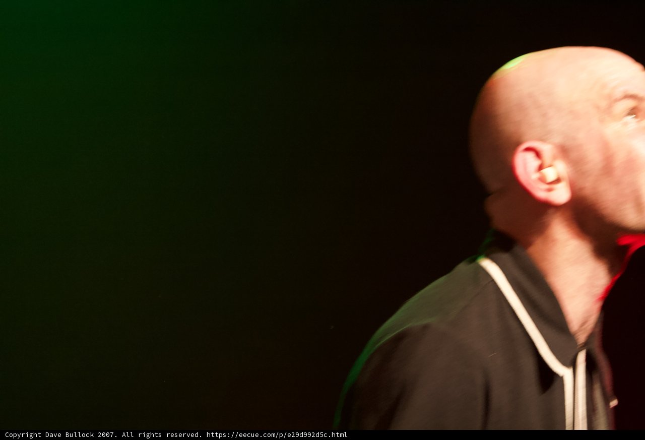 Bald man with microphone performs at the Glasshouse