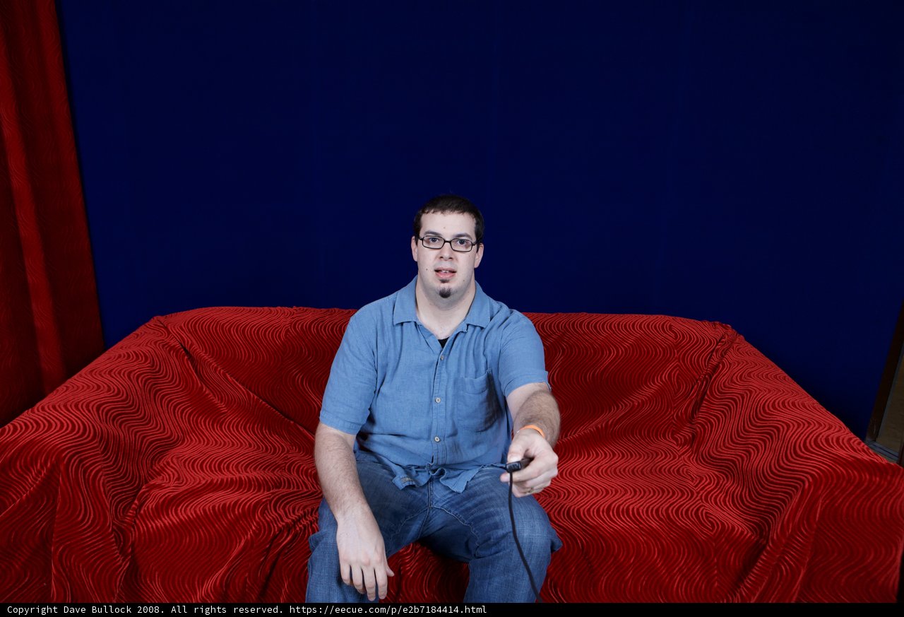 Dave B sitting on a Velvet Red Couch