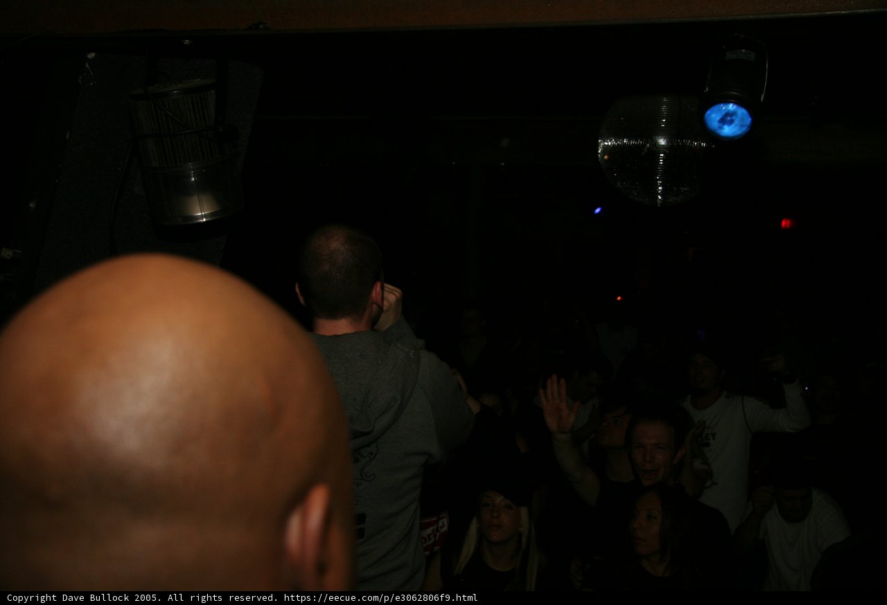 Partygoer stands under the disco ball at a dark nightclub
