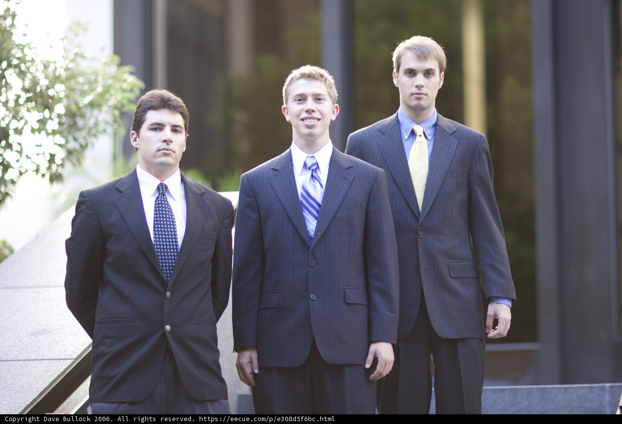 Three Men in Suits Stand Tall