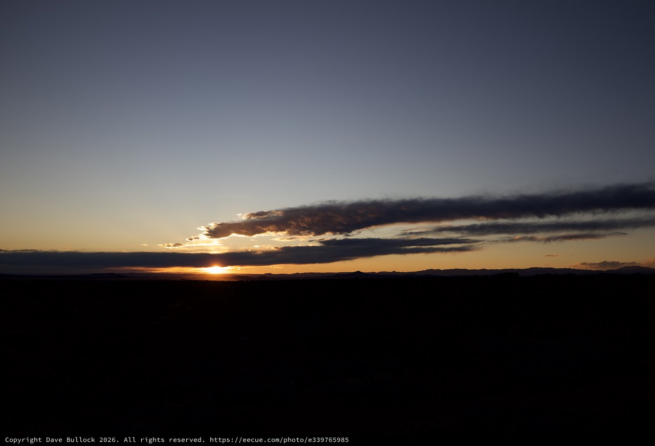 Dramatic Sunset Over Dark Desert Landscape