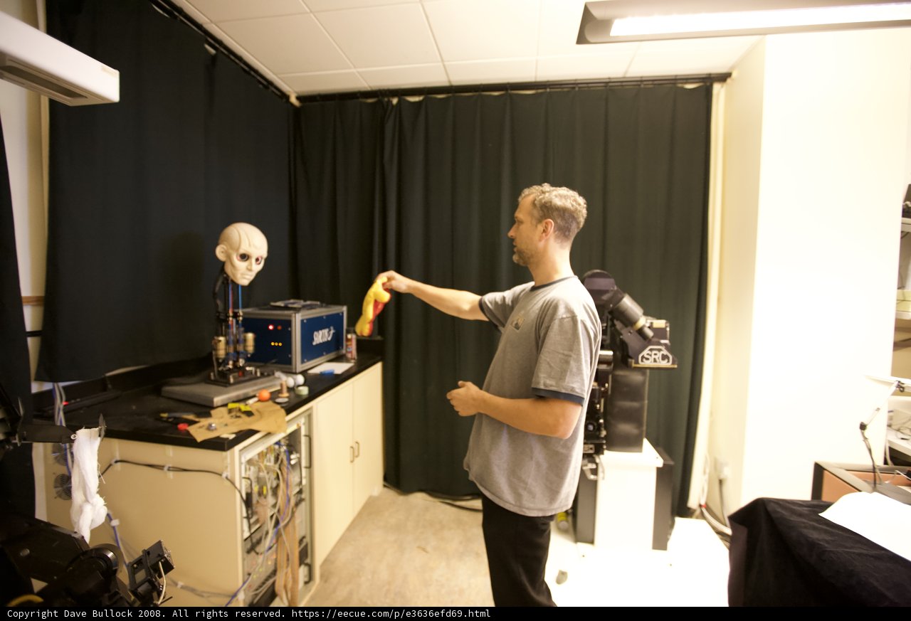 Holding Yellow Object in Workshop