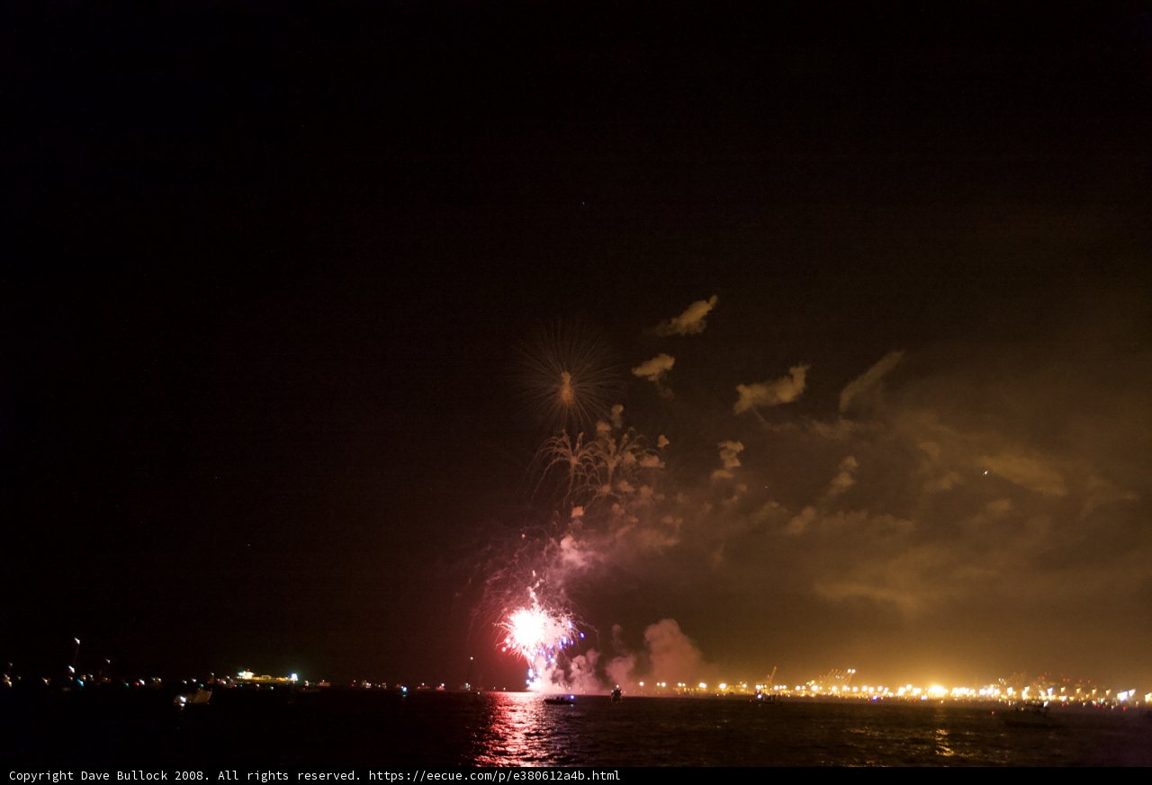 Expansive Fireworks Reflect on Calm Water