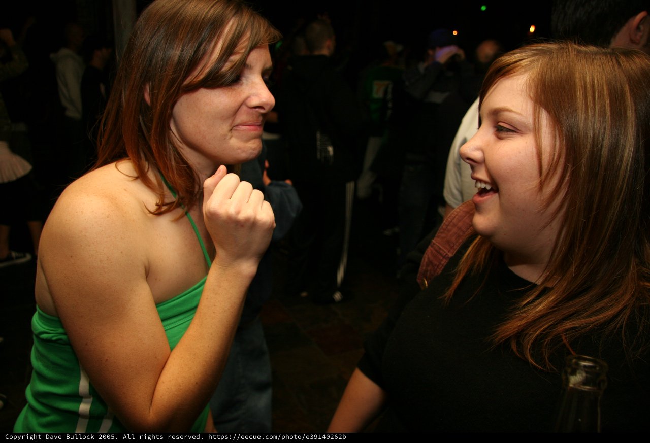 Two Friends Share a Laugh at Nightclub Event