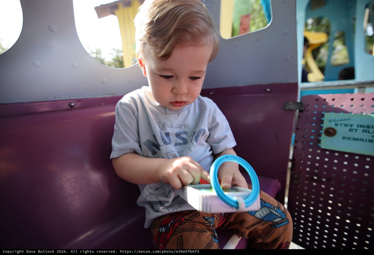 Toddler Playing with Toy at Colorful Playground