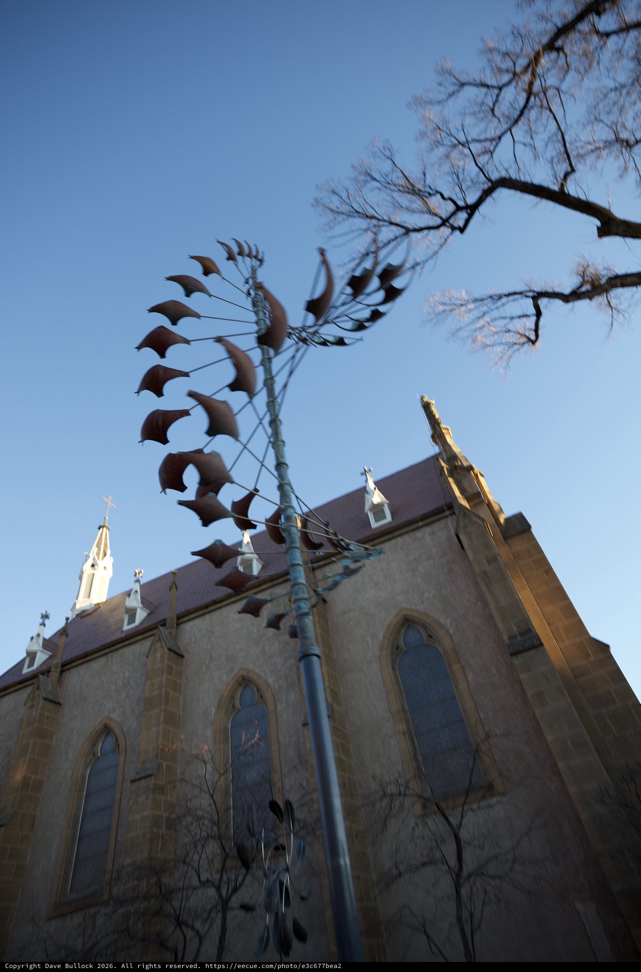 Metal Phoenix Sculpture Against Historic Church at Dusk