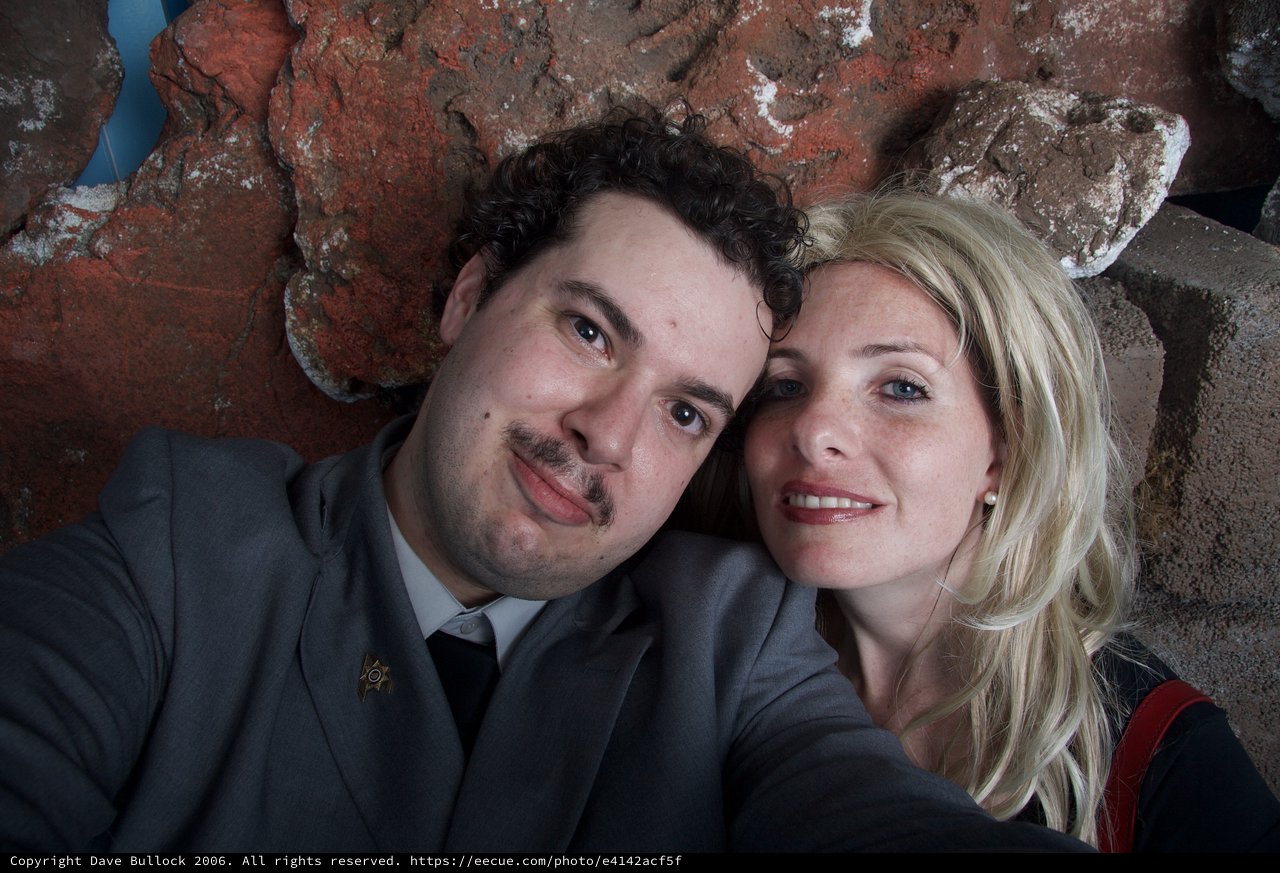 Couple Poses Together Against Rustic Stone Wall