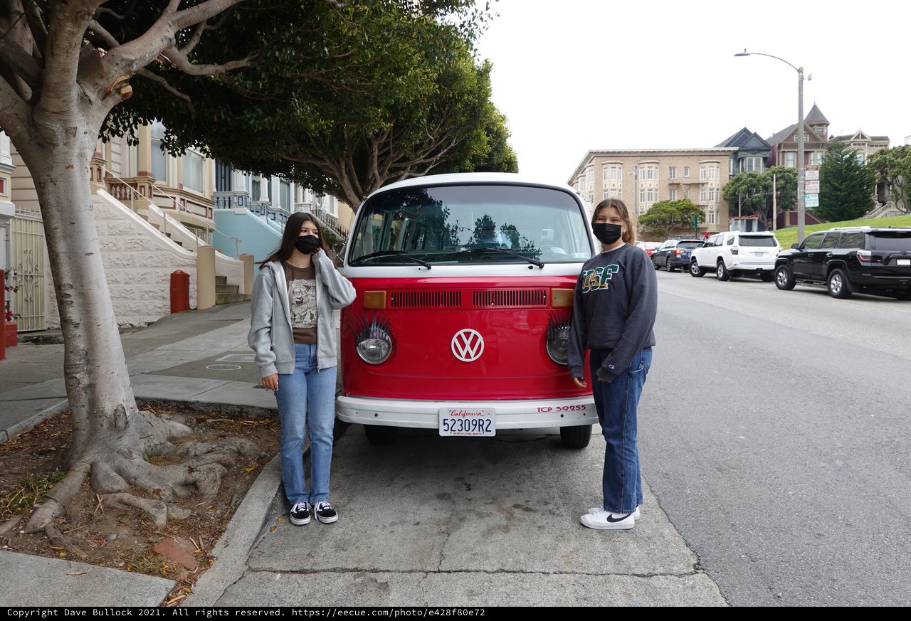 Friends Pose with Classic Red Volkswagen Bus